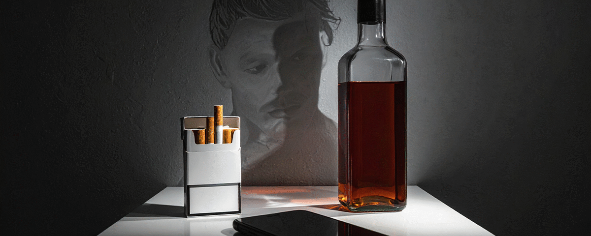 Bağımlılık Tedavisi; Sigara, telefon ve alkolün olduğu bağımlılığı simgeleyen masa.